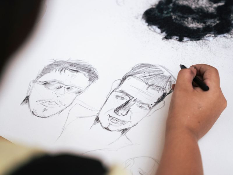 Mano che disegna ritratti a matita