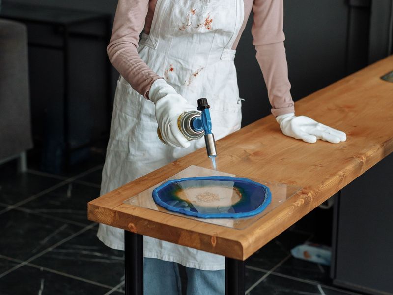 Un'allieva lavora un tavolino in legno e resina