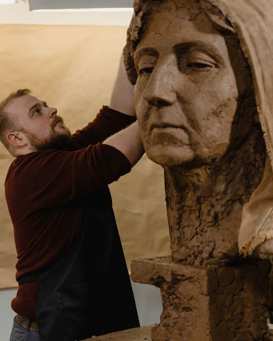 Uno scultore modella una testa ritratto in argilla